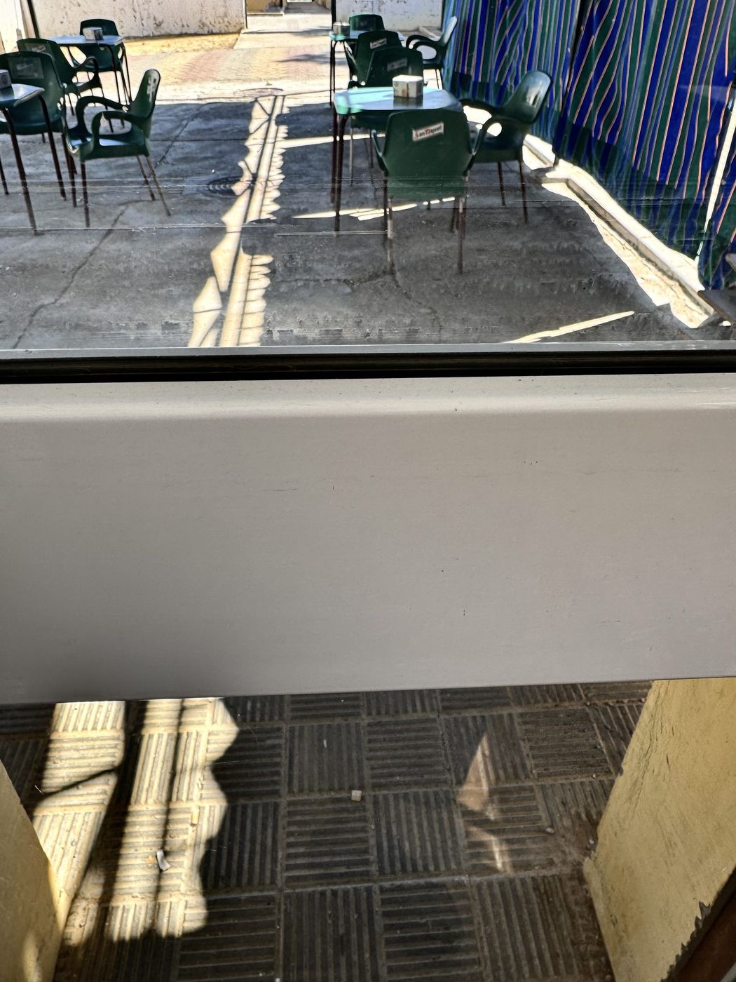 La misma terraza acristalada antes, con cal y restos de lluvia secados