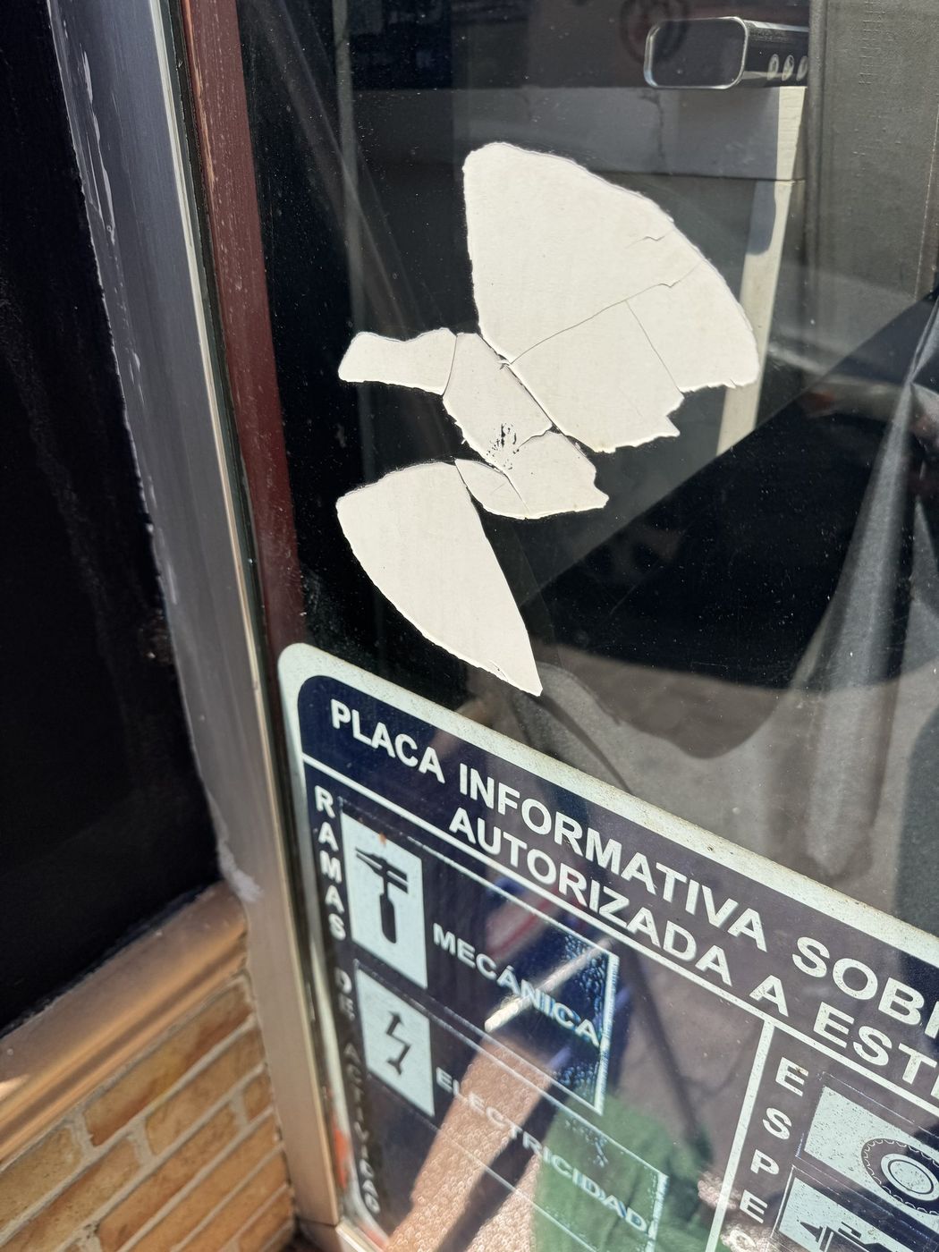 Cristal con pegatinas viejas y restos de adhesivo antes de retirarlas